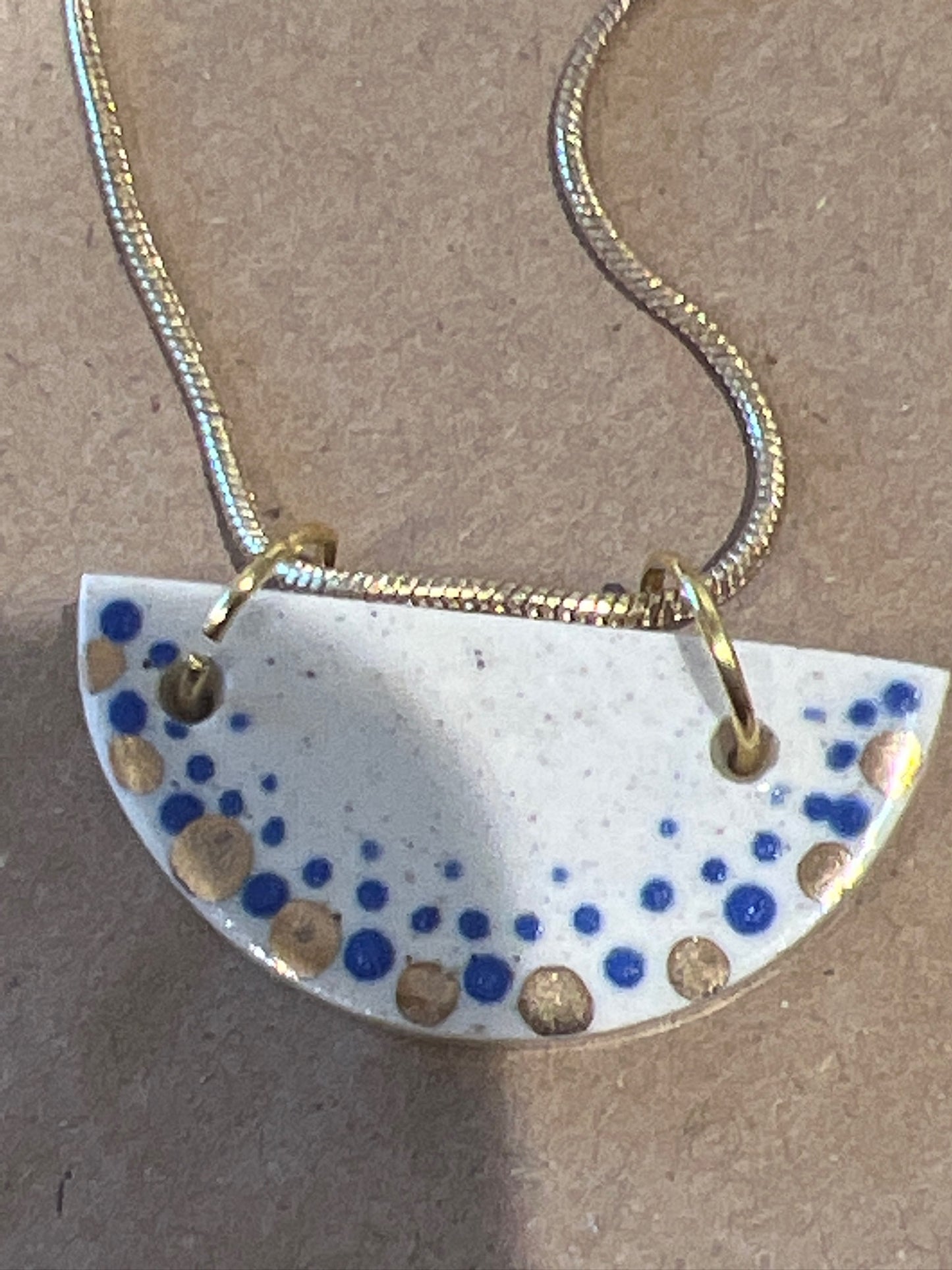 Half circle necklace with gold dot pattern